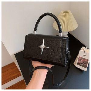 Close-up of black lychee grain leather crossbody bag with silver star and braided handle