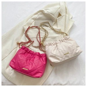 Détail de sacs en cuir matelassé avec chaînes dorées et décor de boules ajustables