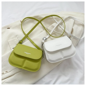 Detail view of grass green and white crossbody bags with dual-grid embossed patterns