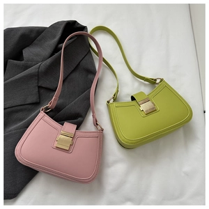 Détail de sacs sous le bras demi-lune rose poudré et vert avec boucles dorées