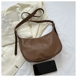 Close-up of brown lychee-textured leather hobo bag with adjustable strap and gold hardware