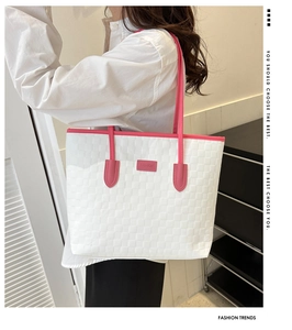 Détail de la texture tissée carrée et des poignées roses sur le grand sac cabas blanc