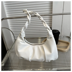 Detailed macro view of white pleated hobo bag with a distinctive twisted braided handle