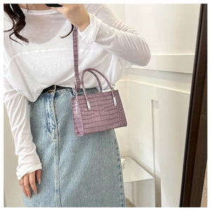 Detailed view of purple crocodile pattern small square bag with silver metal hardware