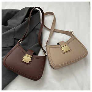 Détail de sacs baguette vintage marron et beige avec boucles en métal doré carré