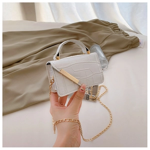 Detail of white crocodile pattern mini bag with gold chain strap and metal buckle