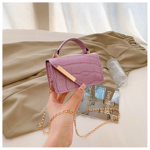 Detail of purple crocodile-pattern square bag with gold metal buckle and chain strap