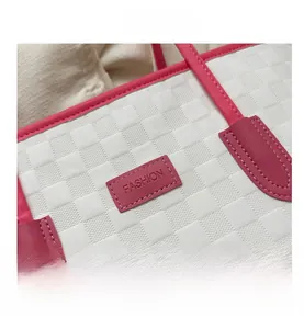 Détail d'un cabas blanc tissé avec lanières en cuir rose et étiquette Fashion