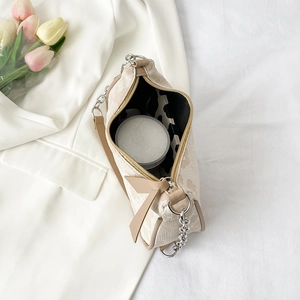Chic beige shoulder bag with pink floral patterns and decorative silver chain