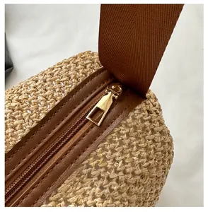 Détail du sac cabas en paille tissée avec fermeture éclair marron et tirette en métal