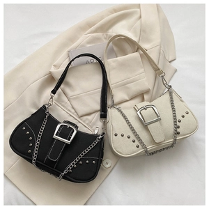 Detail view of denim canvas bags with metal buckles, punk studs, and silver chain straps