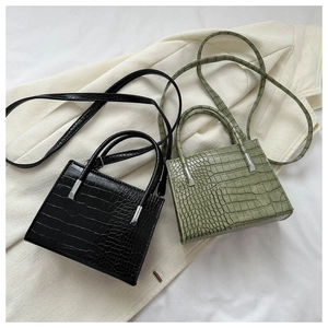 Detail of stone textured tote bags in black and olive green with silver hardware