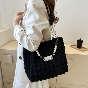 Modern black quilted tote bag with pearl chain strap and leather shoulder handle