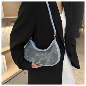 Light blue leather and denim crescent underarm bag styled with a professional black blazer