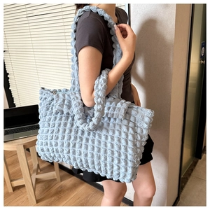 Detail of light blue popcorn textured tote bag showing unique 3D bubble fabric and zipper