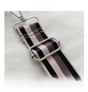 Close-up of adjustable striped woven shoulder strap with silver metal lobster clasps