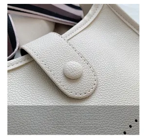 Detailed macro view of cream litchi texture leather bucket bag with magnetic clasp