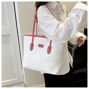 Détail du grand sac cabas crème avec anses roses porté par un mannequin en extérieur