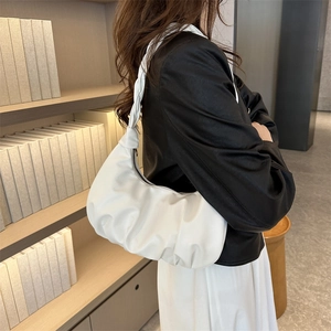 Minimalist white pleated dumpling bag with woven shoulder strap and zipper closure