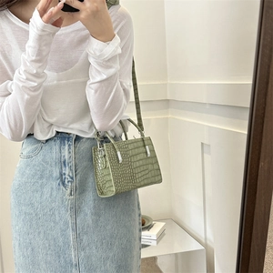 Light green crocodile pattern tote bag with silver hardware shown in mirror selfie