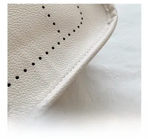 Detail view of pebbled leather texture and neat stitching on a cream bucket bag
