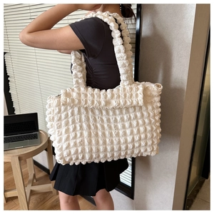 Detail showing white bubble texture fabric and large capacity of the stylish tote bag