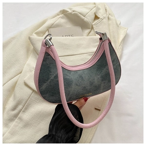 Detail of crescent denim bag showing pink leather trim and silver zipper hardware