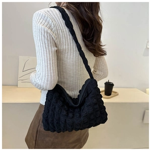 Détail du sac cabas noir à texture bulle montrant le tissu plissé et la bandoulière