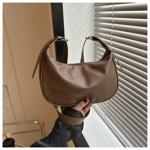 Detailed close-up of brown litchi pattern PU leather on a minimalist crescent hobo bag