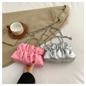 Close-up of pleated cloud clutch bags with rhinestone handles and chain straps