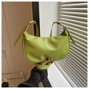 Close-up of bright green litchi texture leather tote bag with golden metal hardware detail