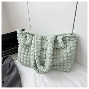 Detail view of the light green popcorn texture and secure zipper on this cloud tote bag