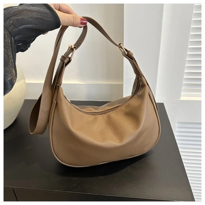 Detailed macro view of the brown hobo bag showing high-quality pebbled leather texture