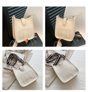 Detailed views of a beige lychee leather bucket bag with a striped crossbody strap