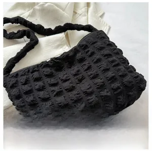 Détail du sac cabas noir à texture bulle avec bandoulière froncée en tissu gaufré