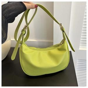Close-up of litchi-textured green crescent bag with zipper and gold hardware details
