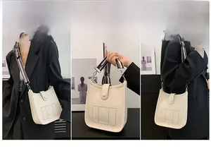 Detailed view of white litchi leather bucket bag featuring a hollow-out H design