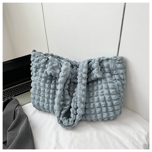 Detail of light blue bubble textured tote bag featuring a high-capacity design and zipper closure