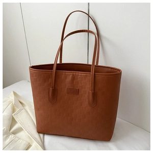 Détail du sac cabas marron tissé avec étiquette en cuir FASHION et texture
