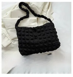 Vue de dessus du sac à bandoulière noir en tissu popcorn avec téléphone de référence