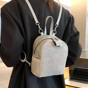 Mini zaino grigio con strass argentati e spallacci regolabili in un contesto lifestyle