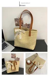 Detail of beige straw tote bag featuring a lace bow and brown leather shoulder straps