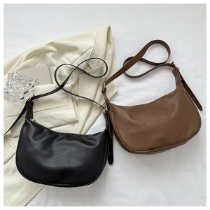 Flat lay of black and brown hobo shoulder bags with adjustable straps on white background