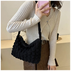 Détail du tissu à bulles noir sur un sac à bandoulière élégant pour femmes