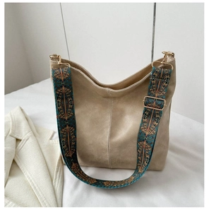 Detail of beige hobo bag featuring a colorful geometric print wide shoulder strap