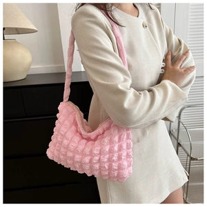 Vue détaillée du sac à bandoulière rose avec texture à bulles et fermeture à glissière
