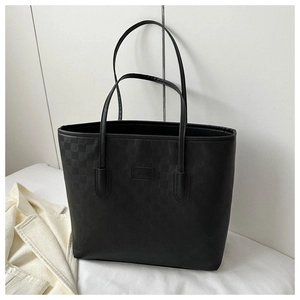Détail du cabas noir à motif damier avec plaque tendance et texture en cuir premium