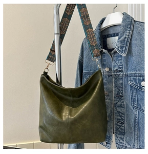 Detail of dark green hobo bag featuring a retro ethnic geometric patterned wide strap