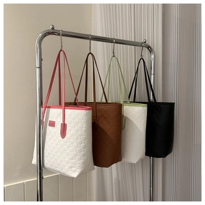 Détail de la texture tissée et des couleurs des grands sacs cabas minimalistes avec logo