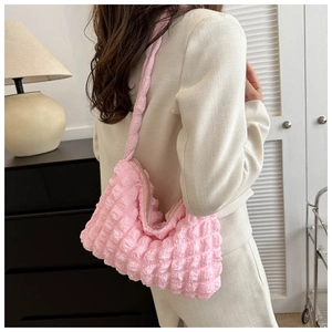 Sac bandoulière rose à texture bulle montrant sa coupe souple et son tissu 3D unique